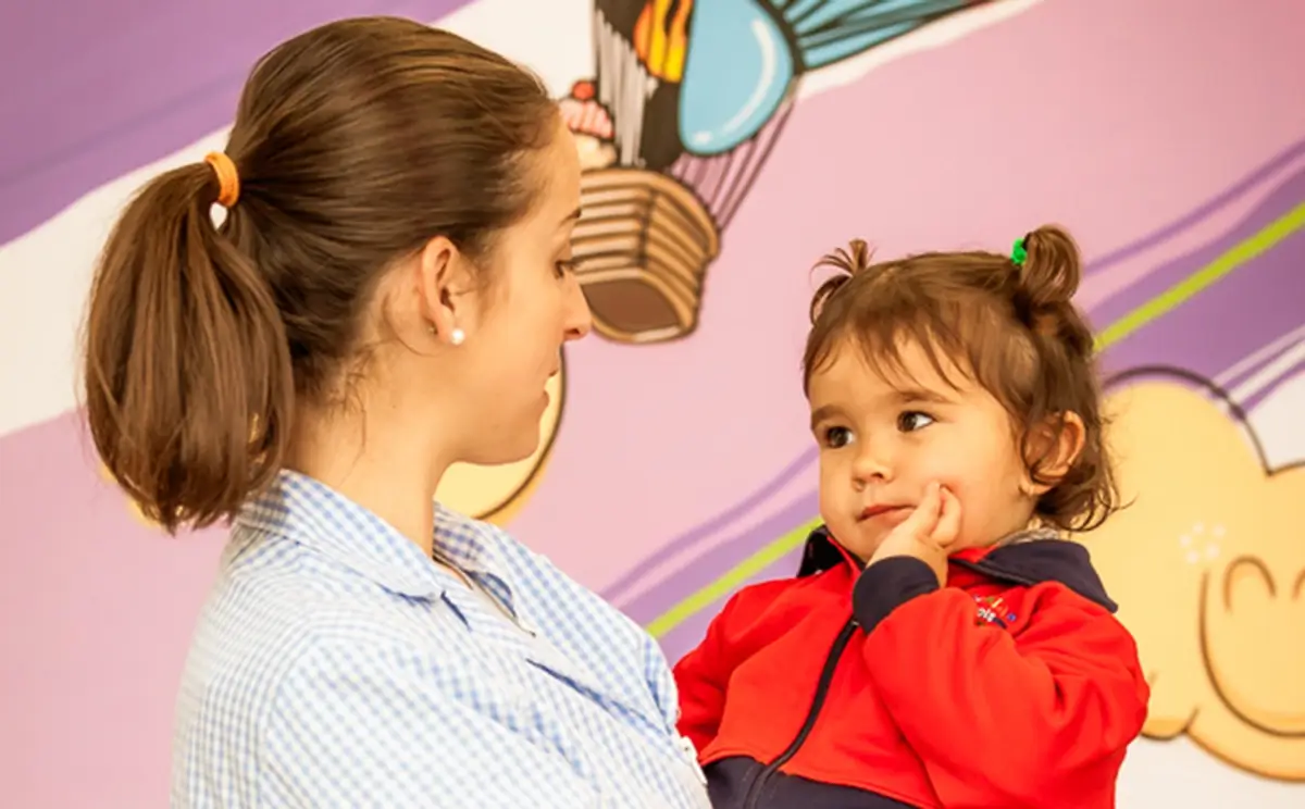 Educadora de escuela infantil hablando con su alumna