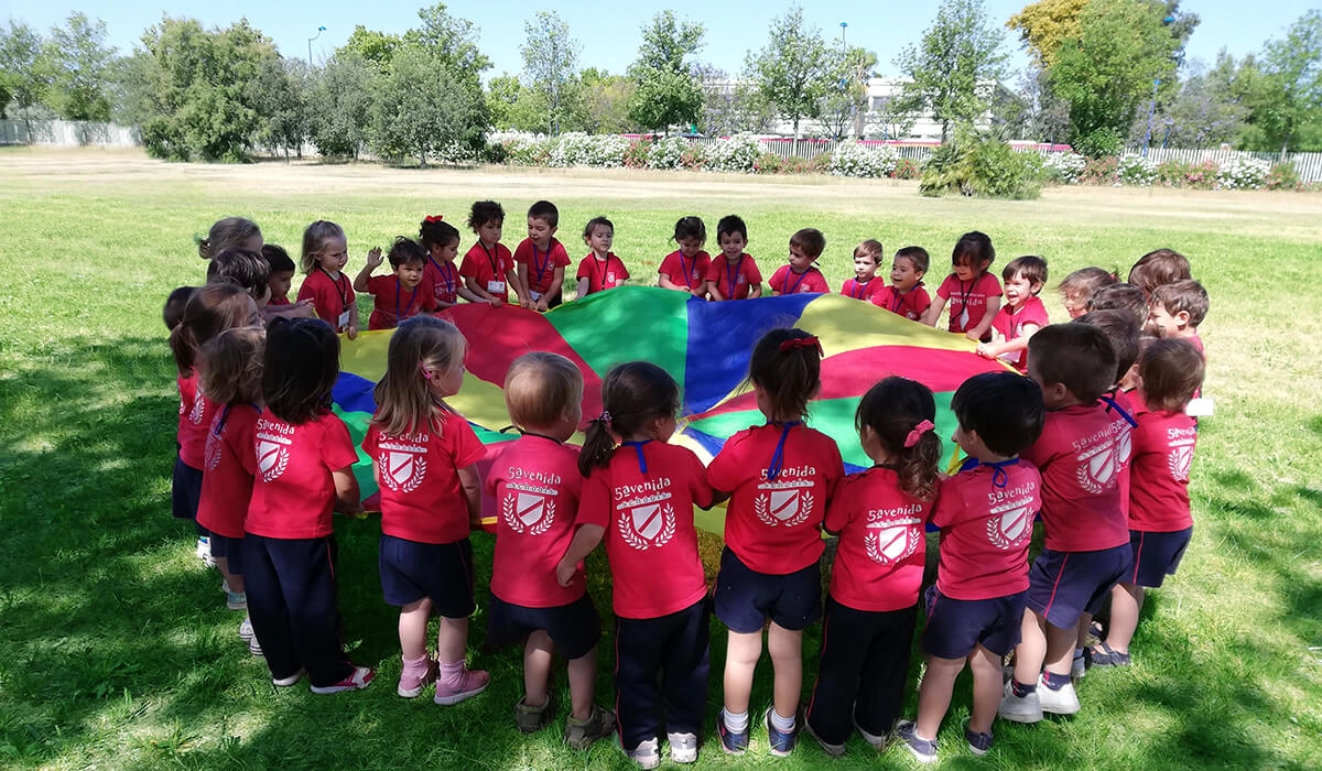 niños escuela infantil jugando con un paracaidas